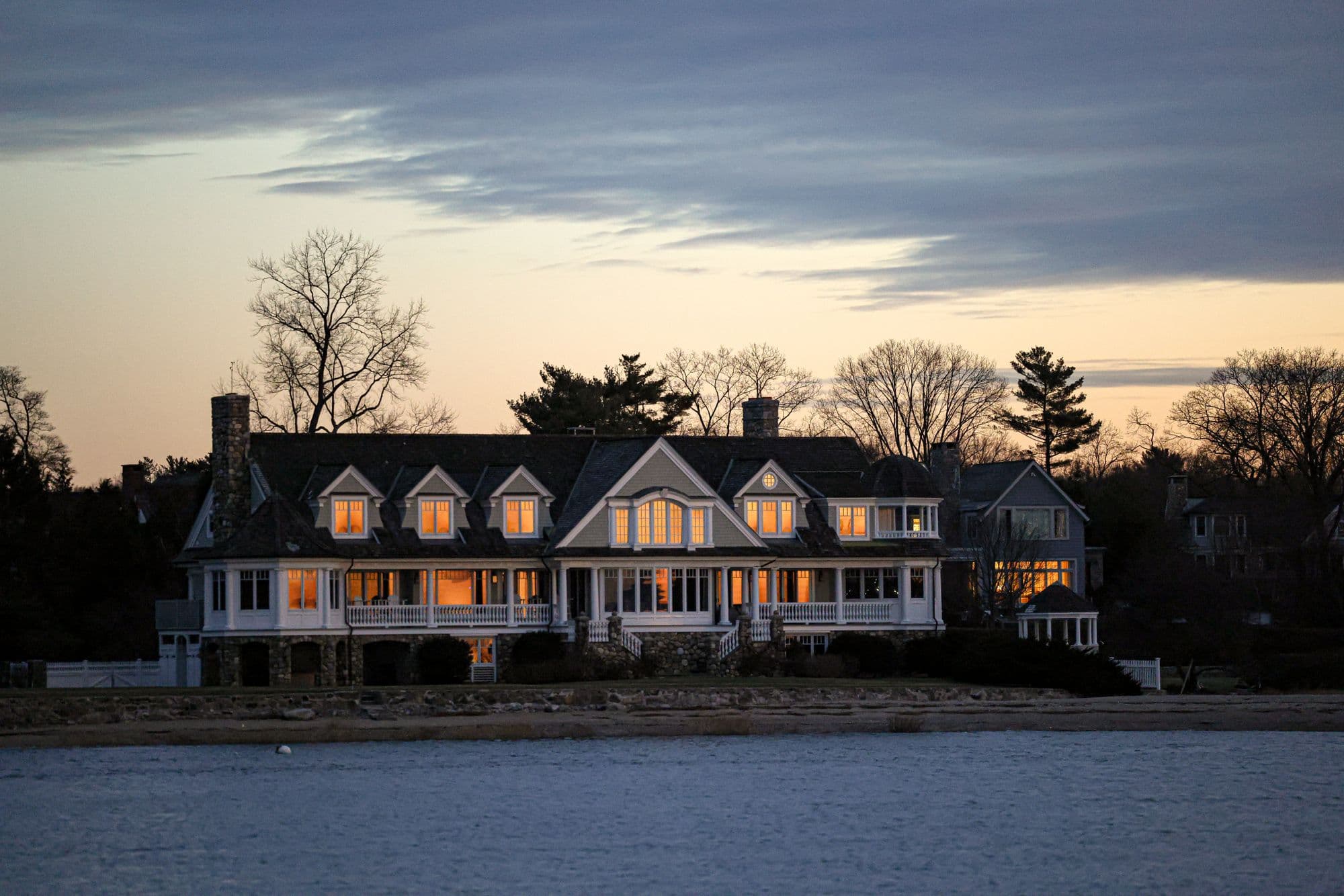 A luxury waterfront estate glowing at twilight